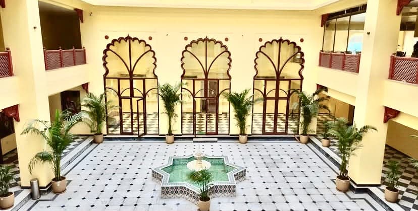 Central courtyard with octagonal mosaic fountain, cusped arch glazing and checkerboard marble flooring