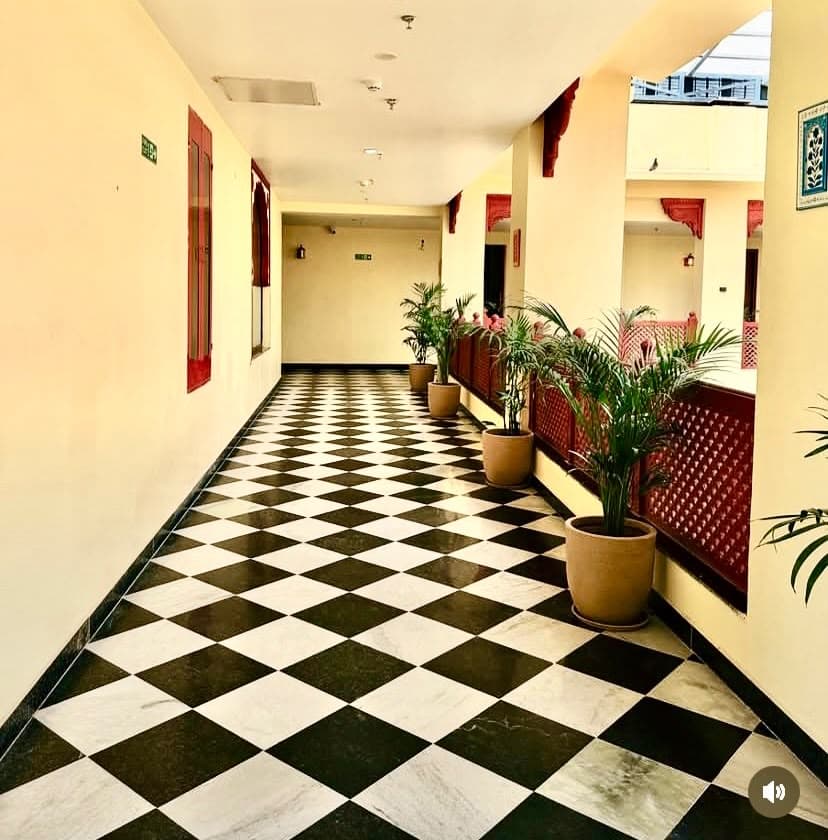 Classical checkerboard marble circulation gallery with carved bracket details and natural greenery