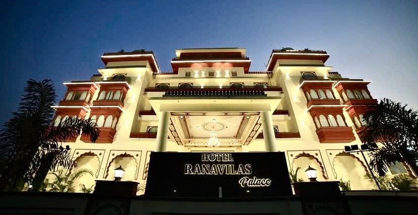 Dusk elevation of Hotel Ranavilas Palace with warm architectural illumination highlighting the classical portico entrance
