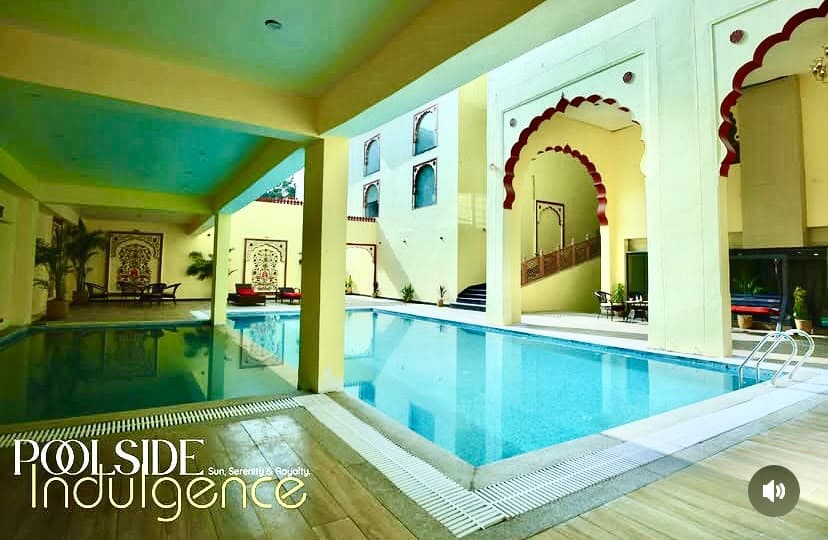 Poolside colonnade with Rajasthani cusped arches and water reflection