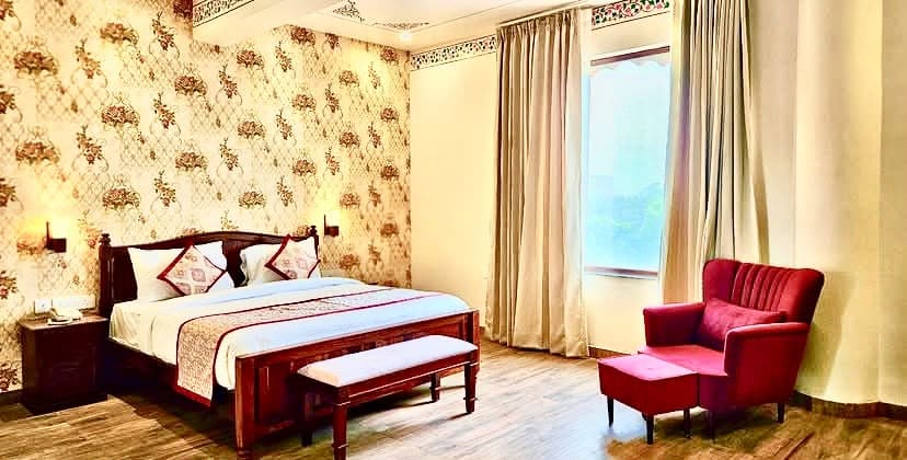 Regal hotel bedroom suite interior featuring handcrafted wooden bed, bespoke armchair and traditional detailing