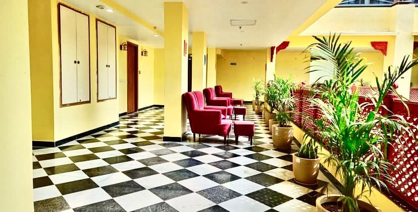 Upper gallery verandah corridor with red sandstone jaali balustrades, seating alcoves and checkerboard flooring